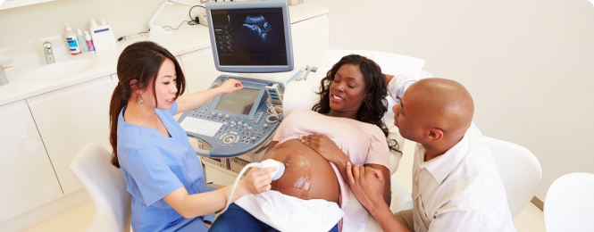 reason-to-join-img (5) Pregnant woman receiving an ultrasound with a clinician guiding the probe as her partner touches her belly, monitor visible in background.